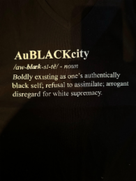 AUBLACKCITY /AW-BLAEK-SI-TĒ/ -NOUN BOLDLY EXISTING AS ONE'S AUTHENTICALLY BLACK SELF; REFUSAL TO ASSIMILATE; ARROGANT DISREGARD FOR WHITE SUPREMACY logo
