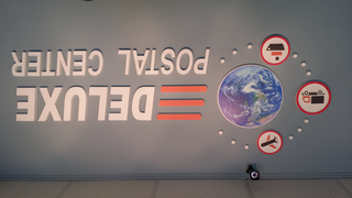 DELUXE POSTAL CENTER logo