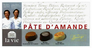 STERNEKOCH THOMAS BÜHNER,  RESTAURANT, LA VIE, CHEFPATISSIER RENÉ FRANK AND  CHOCOLATIER BERNING SCHUFEN RAFFINIERTE  PRALINÉKREATIONEN. RESULTAT : AUBERDEWÖFNLICHE GESCHMACKSKOMPA SITIONEN MIT UATÜRLICHEN ZUTATEN. KLEIHE WUNDERWERKE AUS QUALITÄT AND CREATIVITÄT. PÂTE D' AMANDE LA VIE  MANDEL FLORENTINER MIT LAKRITZ, MANDEL MALS 5 SPICE, MANDEL CRISPY-WAFFEL BERUING'S FEINE CONFISCRSE SELT 1915 logo